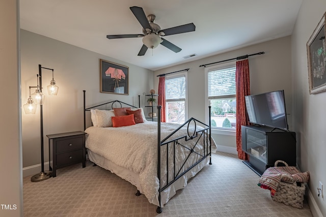 bedroom featuring light colored carpet, baseboards, visible vents, and ceiling fan