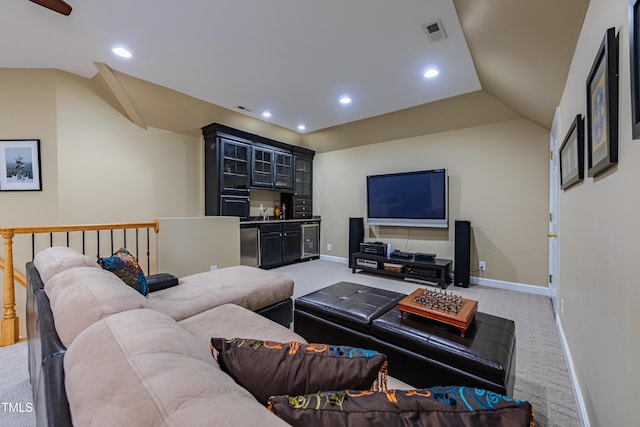 living room with visible vents, vaulted ceiling, baseboards, indoor wet bar, and light carpet