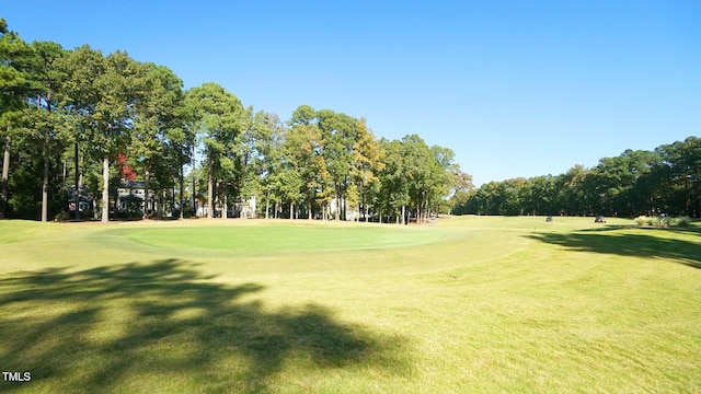 surrounding community featuring golf course view and a yard