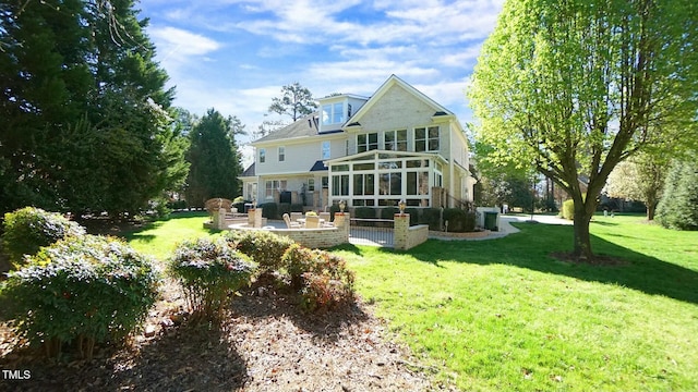 back of property featuring a yard, a patio, an outdoor living space, and a sunroom