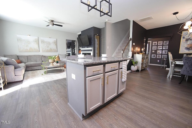 kitchen featuring open floor plan, gray cabinets, ceiling fan with notable chandelier, and dark wood-type flooring