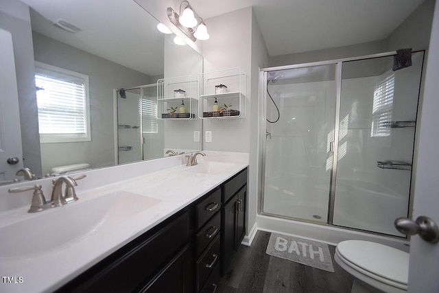 bathroom featuring a sink, a stall shower, toilet, and visible vents