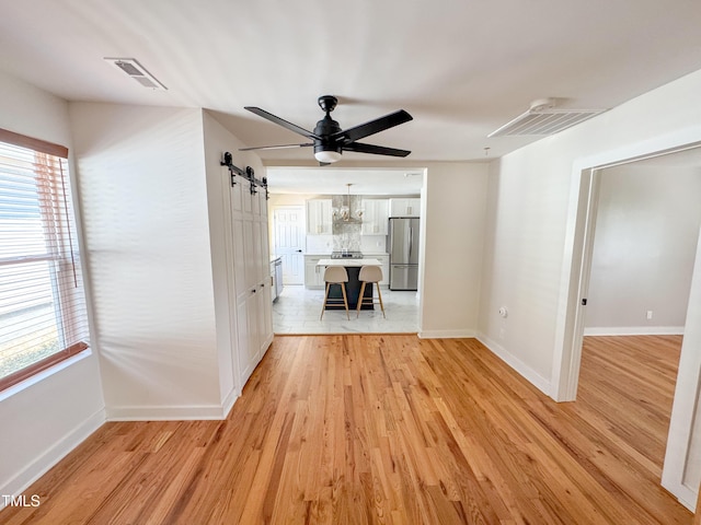 1100 Chester St, Durham, NC 27701 - interior space featuring baseboards, visible vents, a barn door, and light wood finished floors