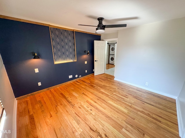 1100 Chester St, Durham, NC 27701 - unfurnished room with baseboards, a ceiling fan, stacked washer / dryer, and wood finished floors