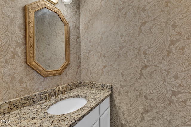bathroom with vanity and wallpapered walls
