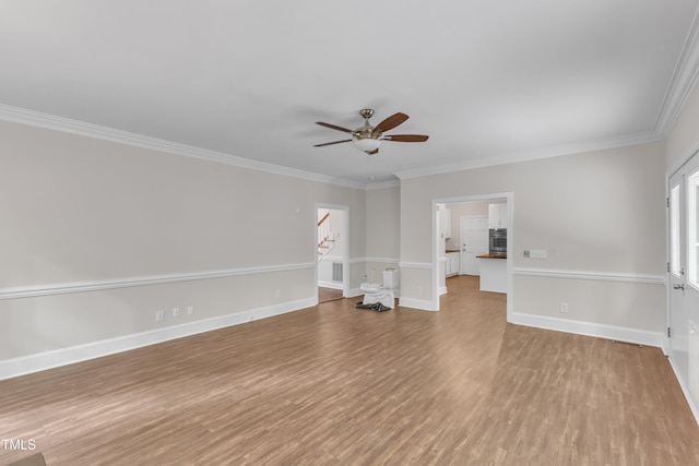 interior space with ceiling fan, crown molding, wood finished floors, stairway, and baseboards