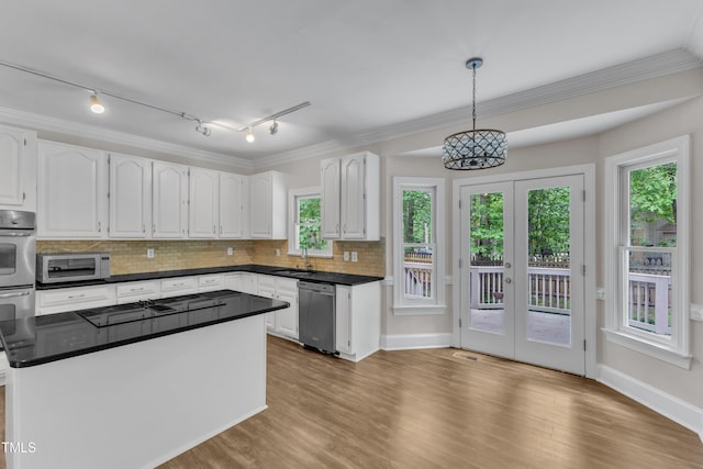 kitchen with white cabinetry, dark countertops, appliances with stainless steel finishes, and decorative backsplash