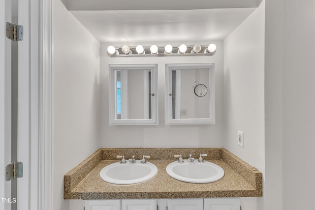 bathroom featuring a sink and double vanity