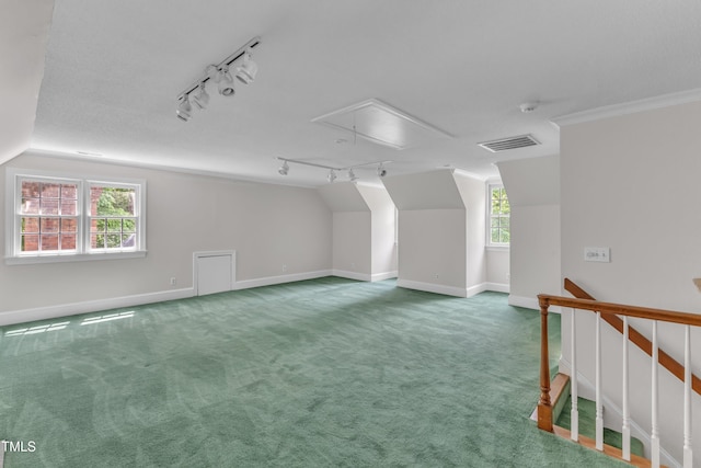 additional living space featuring attic access, visible vents, baseboards, carpet floors, and lofted ceiling