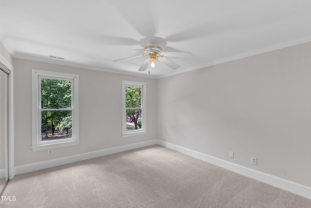 empty room featuring a ceiling fan, baseboards, plenty of natural light, and ornamental molding