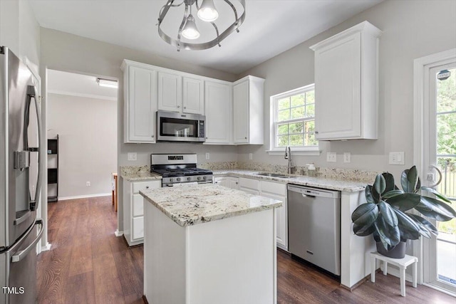 8408 Haines Creek Ln, Raleigh, NC 27616 - kitchen with a sink, white cabinets, dark wood-style floors, an inviting chandelier, and stainless steel appliances