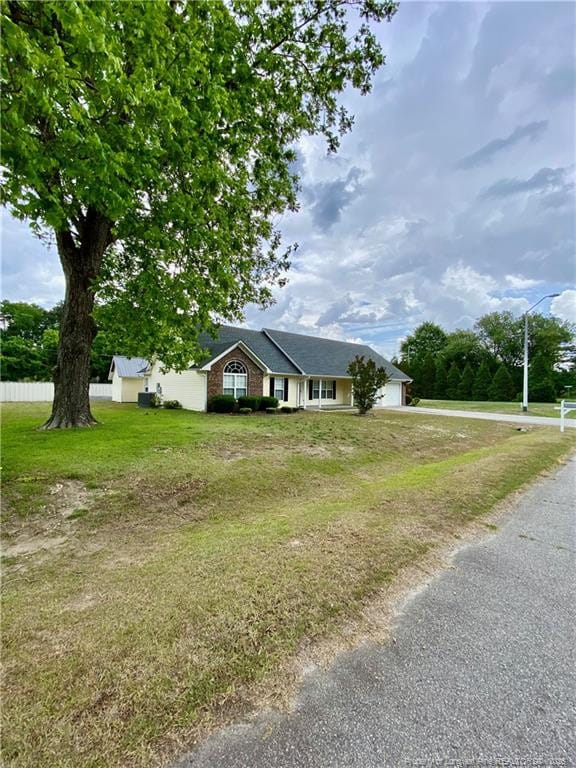 ranch-style house with driveway and a front lawn