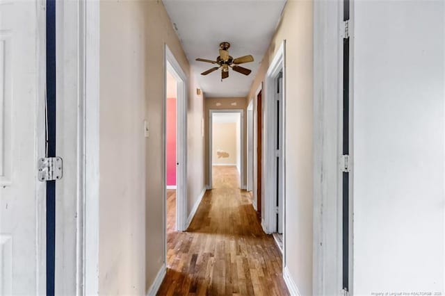 hall featuring baseboards and wood finished floors