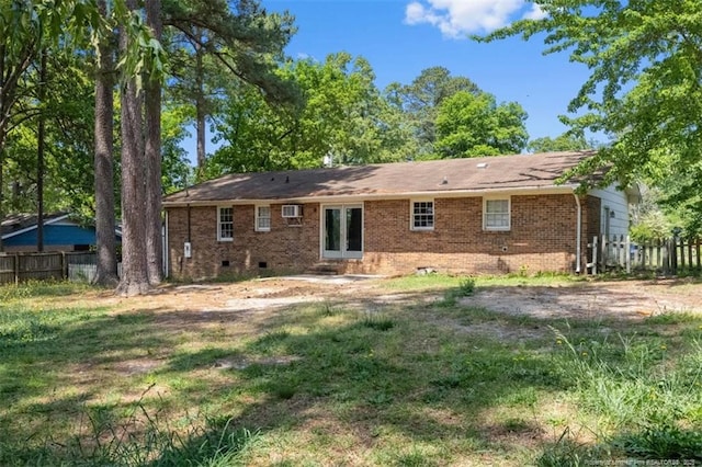 back of property featuring crawl space, brick siding, and fence