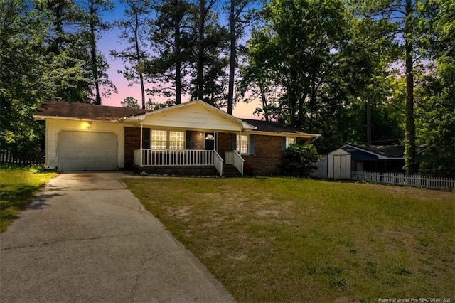 ranch-style house with fence, an attached garage, aphalt driveway, a storage shed, and a porch