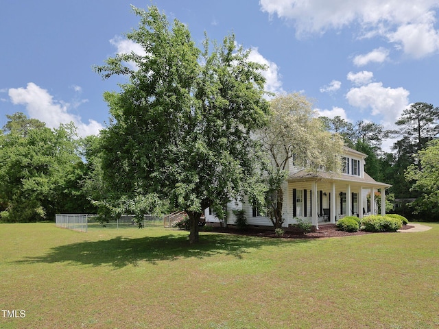 view of front of house with a front lawn, covered porch, and fence