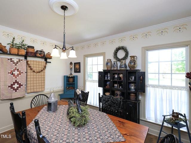 dining area featuring baseboards, ornamental molding, and wood finished floors