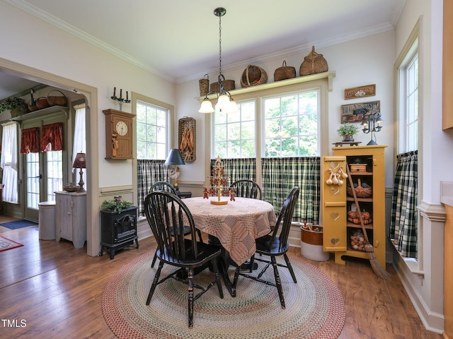 dining space with a chandelier, wood finished floors, and ornamental molding