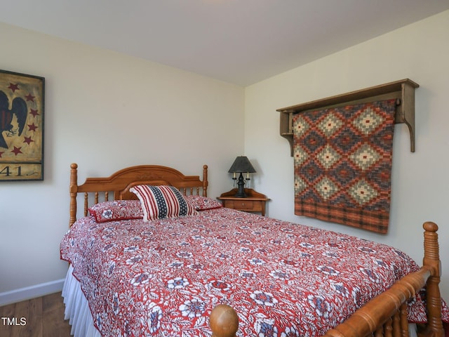 bedroom with baseboards and wood finished floors