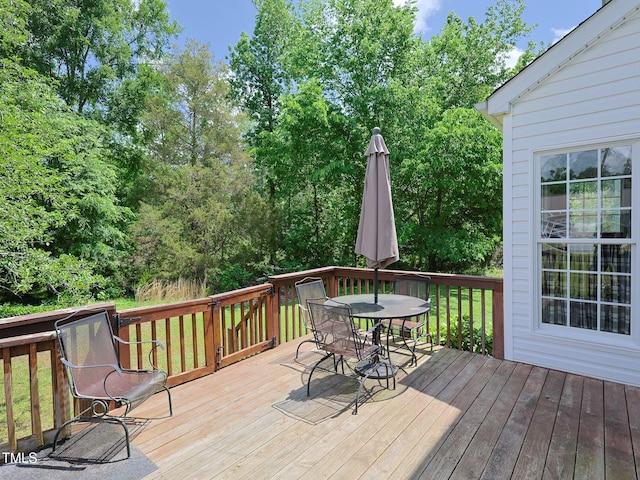 deck with a lawn and outdoor dining area