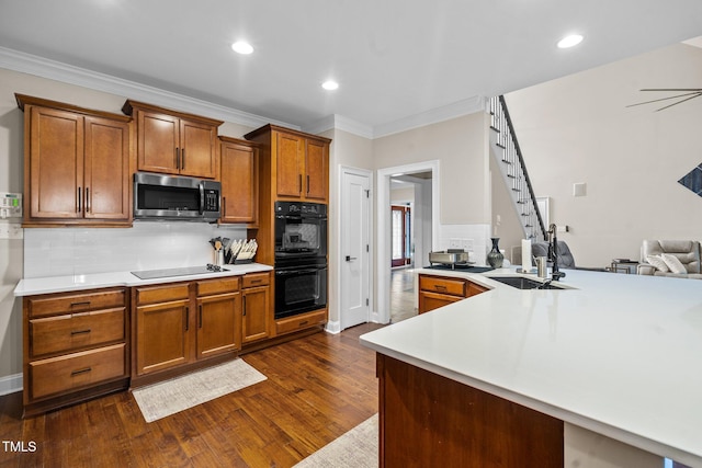 200 Heather Brook Cir, Spring Lake, NC 28390 - kitchen with decorative backsplash, dark wood finished floors, a sink, black appliances, and ornamental molding