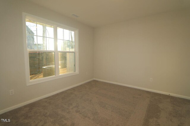 carpeted spare room featuring baseboards