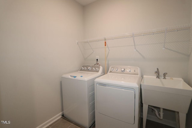 laundry area featuring laundry area, a sink, tile patterned floors, baseboards, and washing machine and dryer