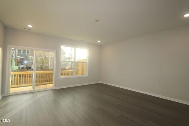 unfurnished room with recessed lighting, baseboards, dark wood finished floors, and visible vents