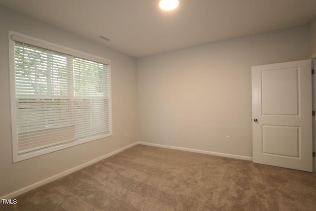 unfurnished room featuring carpet floors, baseboards, and visible vents