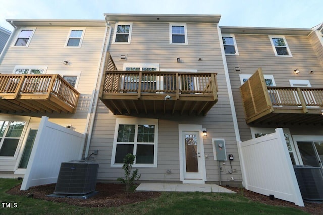 back of house featuring central air condition unit and fence
