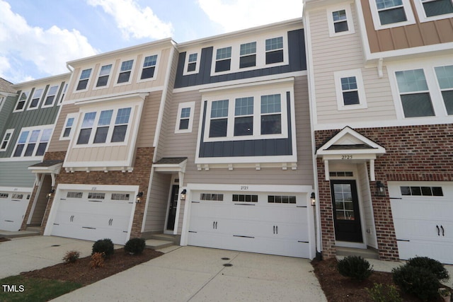 townhome / multi-family property with board and batten siding, an attached garage, and concrete driveway