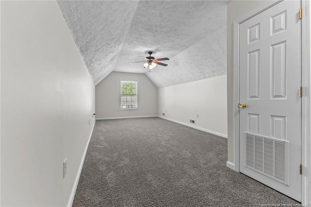 additional living space featuring carpet flooring, a textured ceiling, baseboards, and visible vents