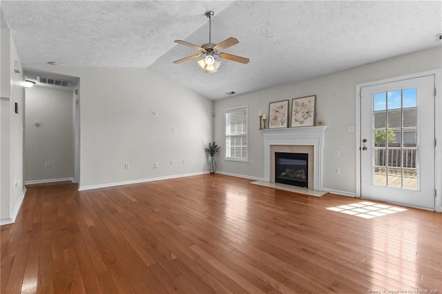 unfurnished living room featuring a ceiling fan, a textured ceiling, visible vents, and a healthy amount of sunlight