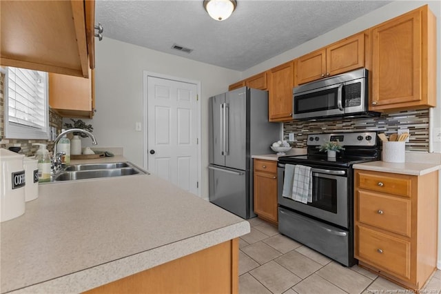 kitchen featuring light countertops, appliances with stainless steel finishes, visible vents, and tasteful backsplash