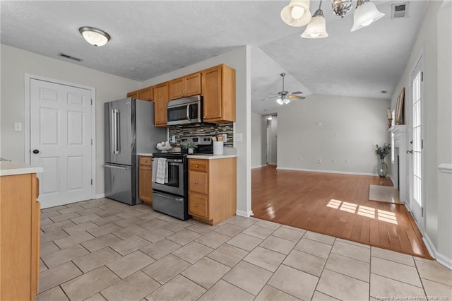 kitchen featuring light countertops, ceiling fan, appliances with stainless steel finishes, and visible vents