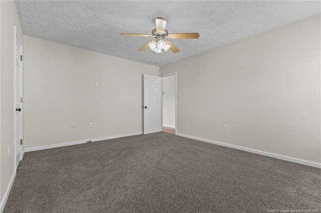 spare room with baseboards, a ceiling fan, a textured ceiling, and dark colored carpet