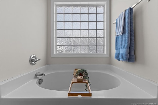 bathroom featuring plenty of natural light and a bath