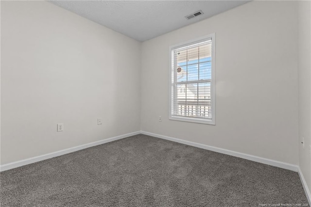 carpeted spare room with baseboards and visible vents