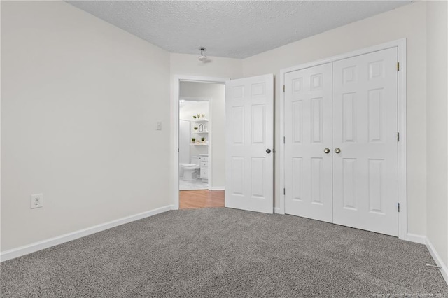 unfurnished bedroom with carpet floors, baseboards, a closet, and a textured ceiling