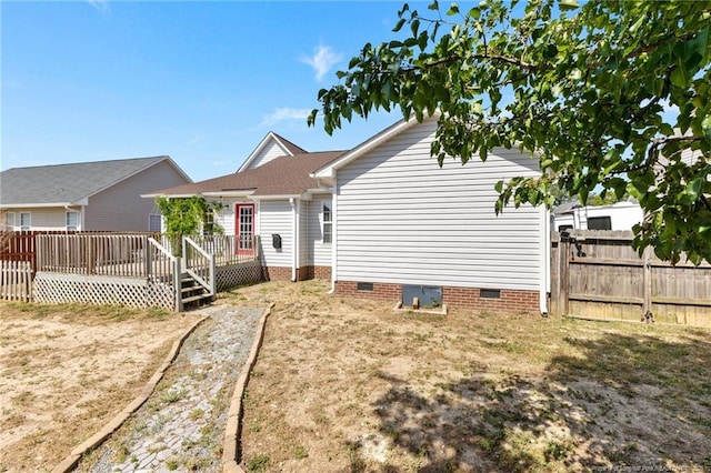 rear view of house featuring crawl space, fence, and a deck