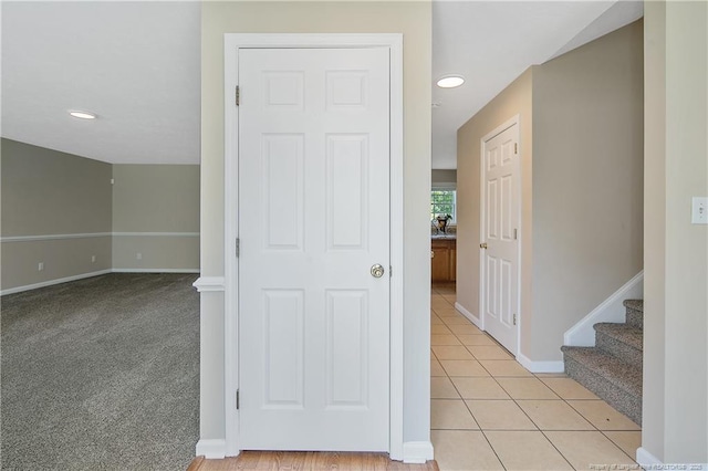 hall featuring recessed lighting, baseboards, and light tile patterned floors