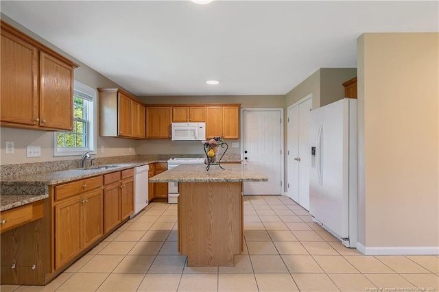 kitchen featuring brown cabinets, a sink, white appliances, recessed lighting, and a kitchen island