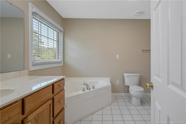bathroom with a bath, vanity, tile patterned floors, baseboards, and toilet