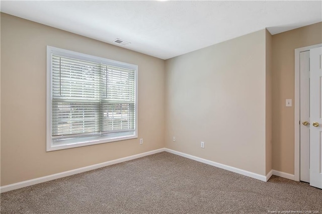 carpeted spare room with baseboards and visible vents