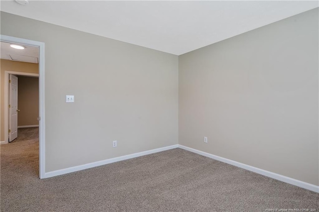carpeted empty room featuring baseboards