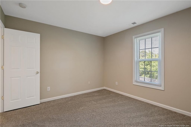 carpeted spare room with baseboards and visible vents