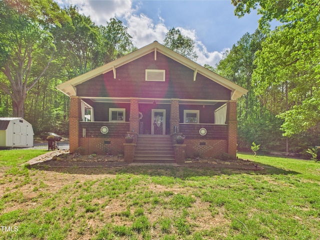 3609 Creekridge Country Rd, Randleman, NC 27317 - view of front facade featuring a porch, crawl space, a front yard, an outbuilding, and a storage unit