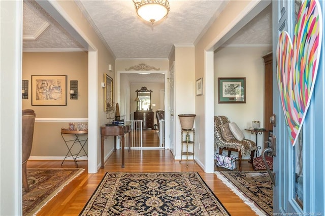 foyer featuring baseboards, a textured ceiling, and wood finished floors