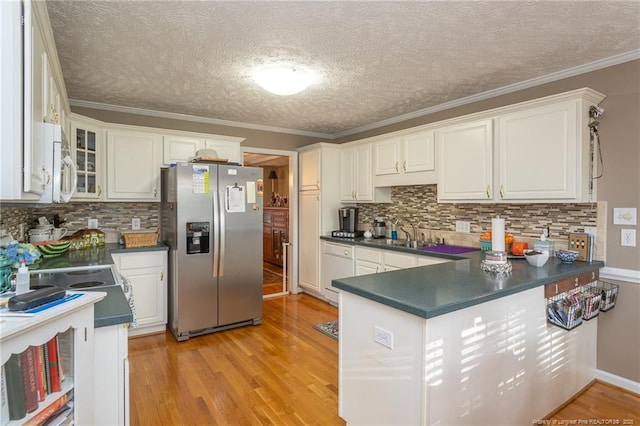 kitchen with white appliances, dark countertops, decorative backsplash, and light wood-style floors