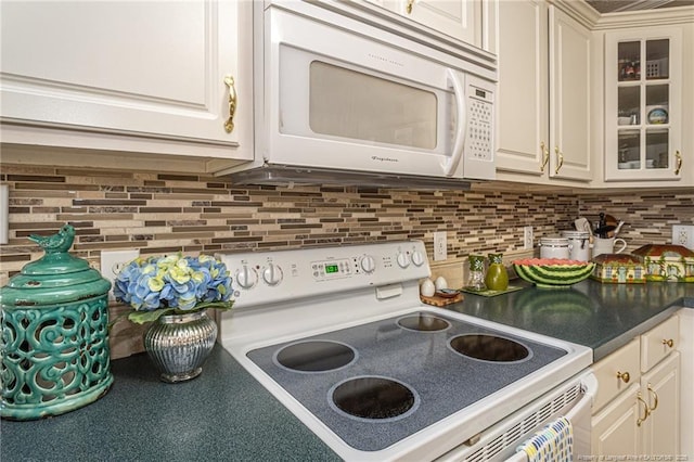 kitchen featuring glass insert cabinets, tasteful backsplash, and white appliances